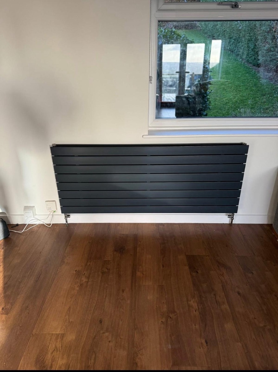 Anthracite flat-panel designer radiator fitted beneath a window by LR Heating, Leeds
