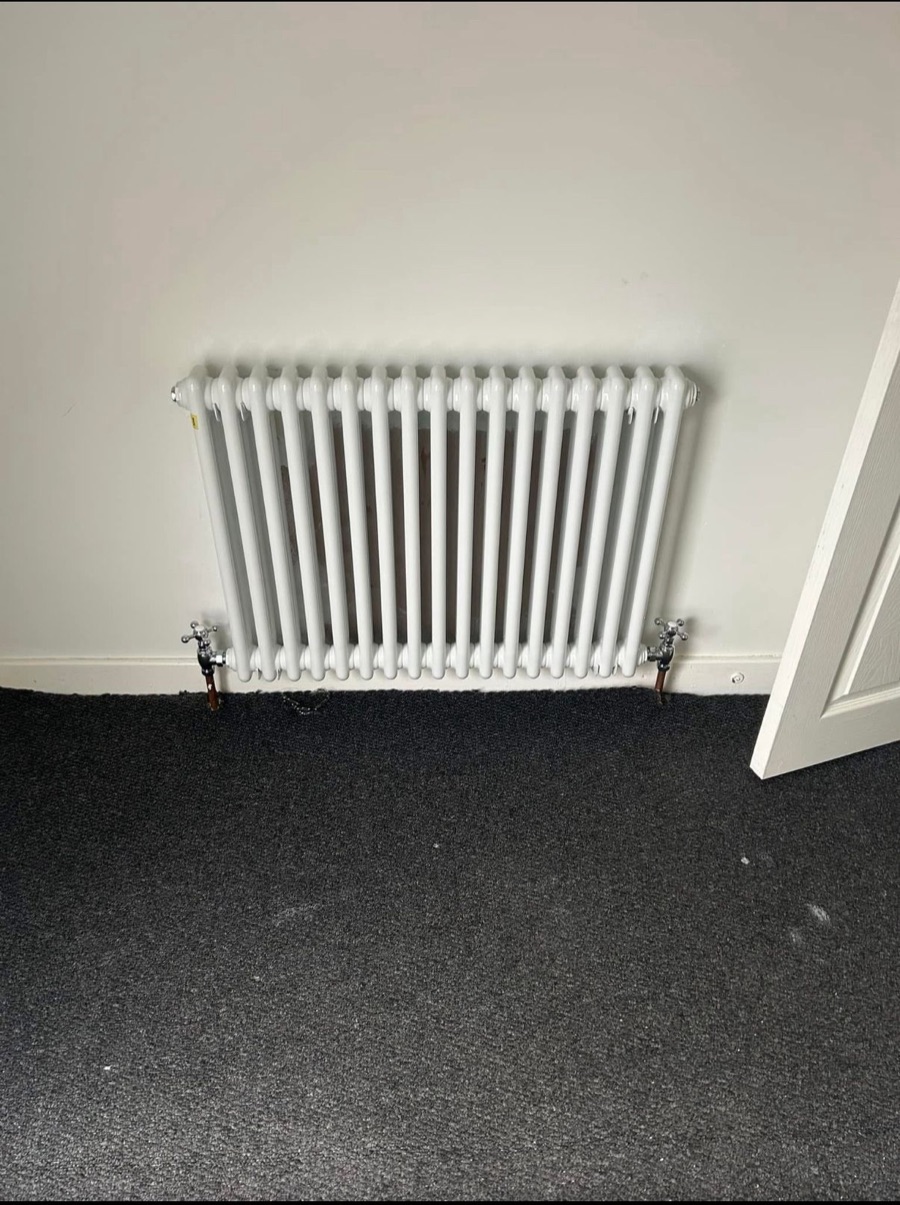 White two-column radiator with chrome valves fitted by LR Heating in Leeds