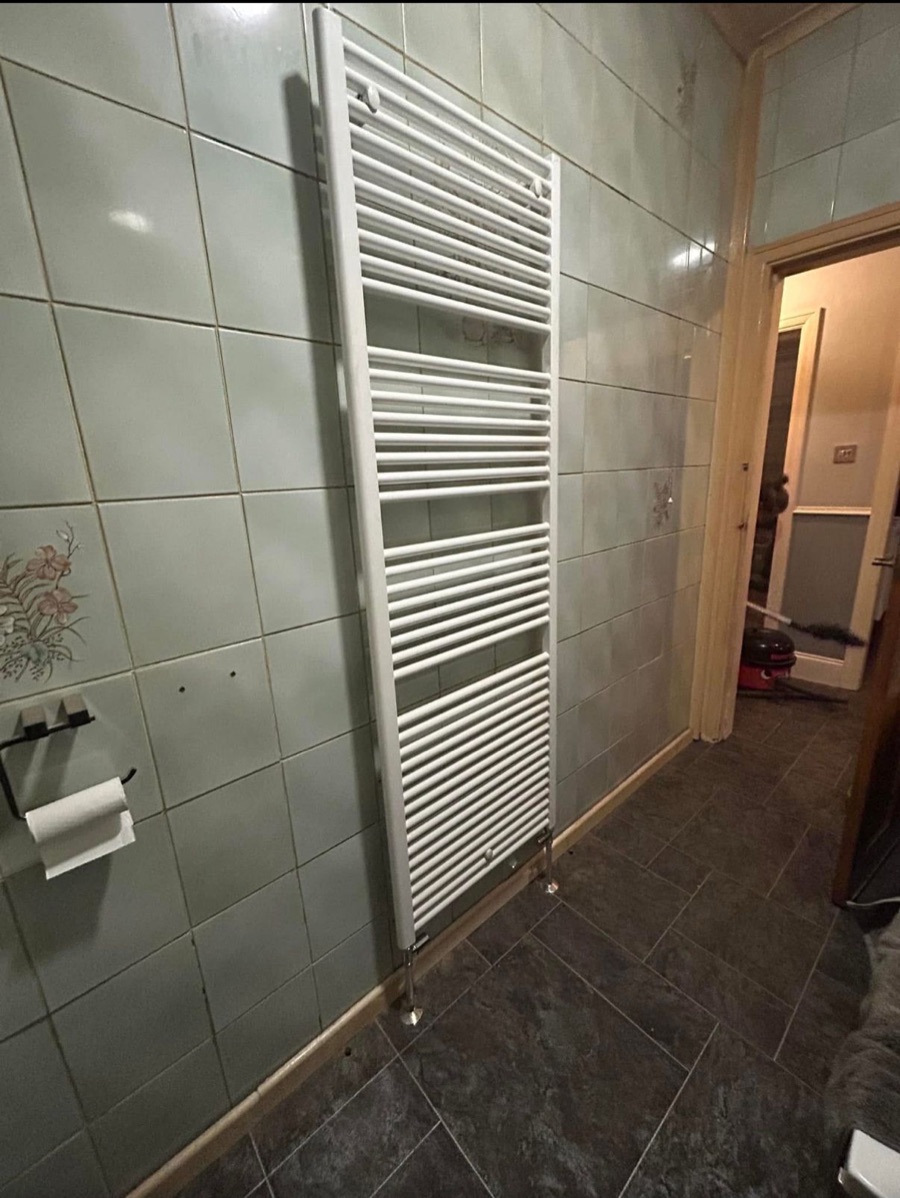White heated towel rail fitted in a tiled bathroom by LR Heating, Leeds