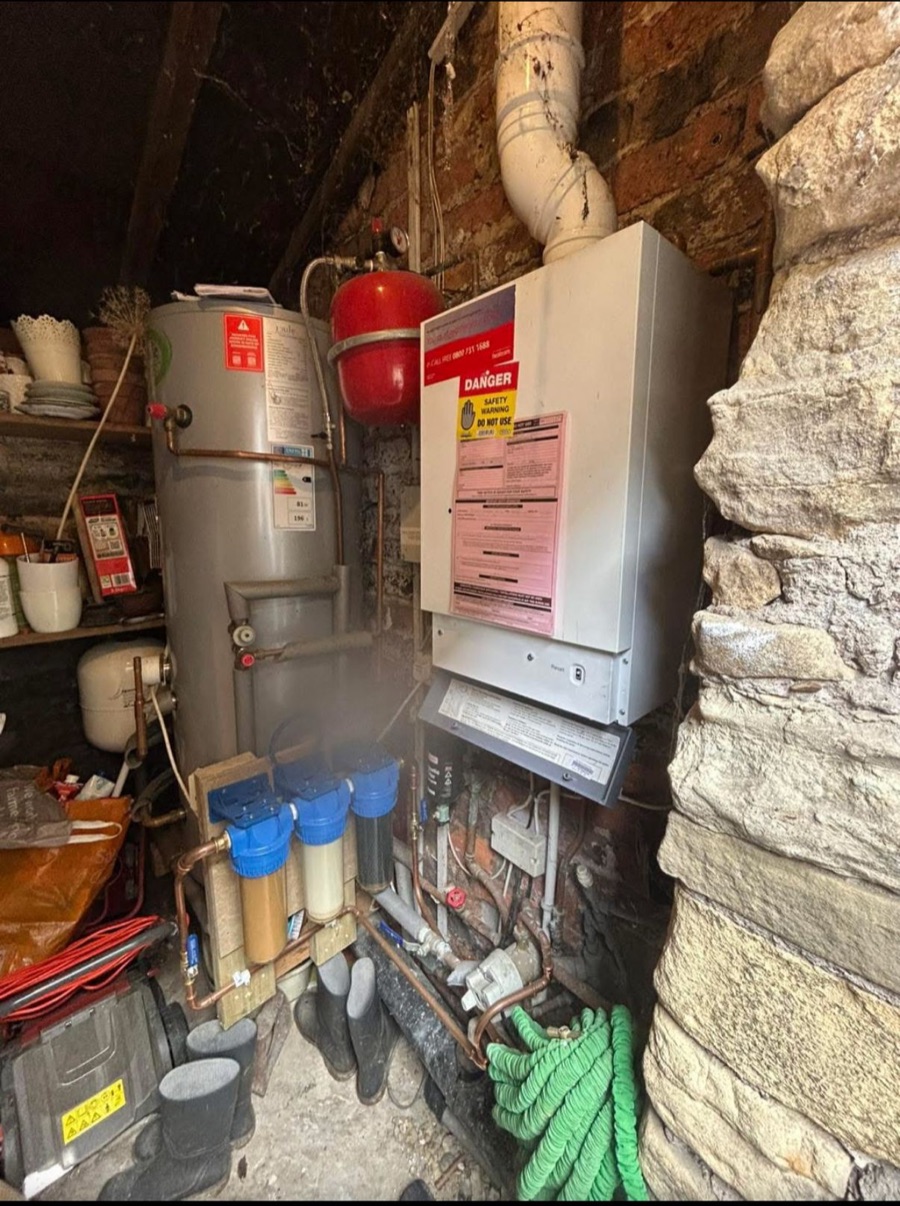 A condemned, unsafe boiler tagged with a warning notice before LR Heating replaced it, Leeds