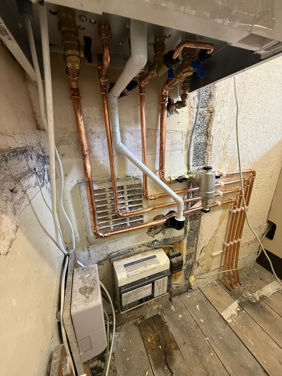 New copper central-heating pipework and magnetic filter with the floorboards lifted, by LR Heating, Leeds