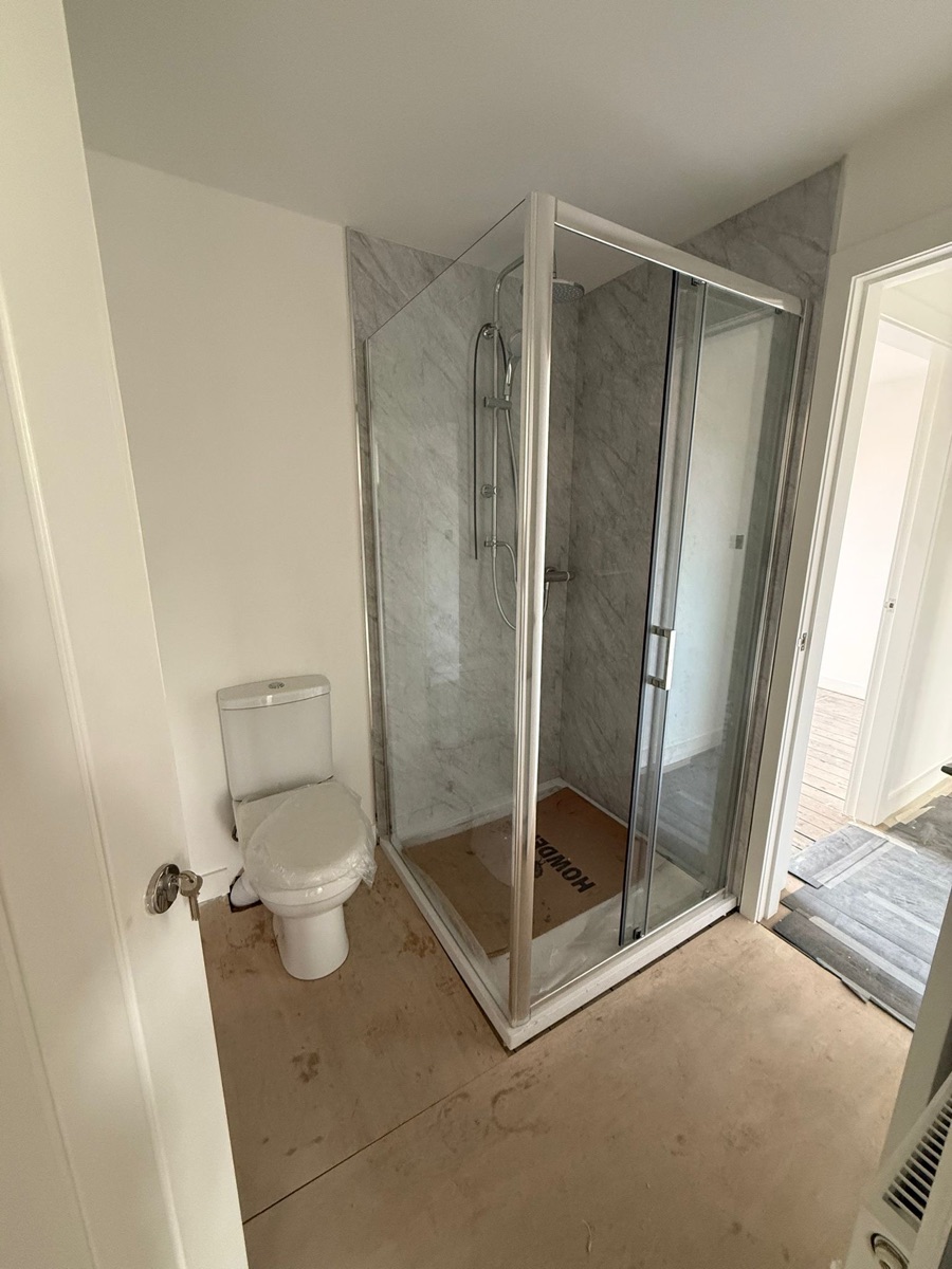 A new corner shower enclosure and WC fitted in a bathroom installation by LR Heating, Leeds