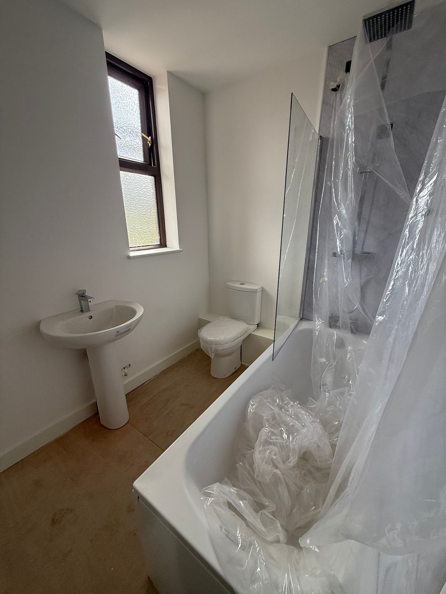 A newly fitted bathroom with bath, basin and shower fitted by LR Heating, Leeds