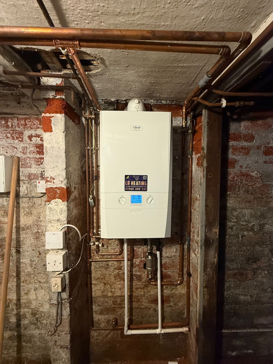 New combi boiler and copper pipework installed on an exposed-brick cellar wall by LR Heating